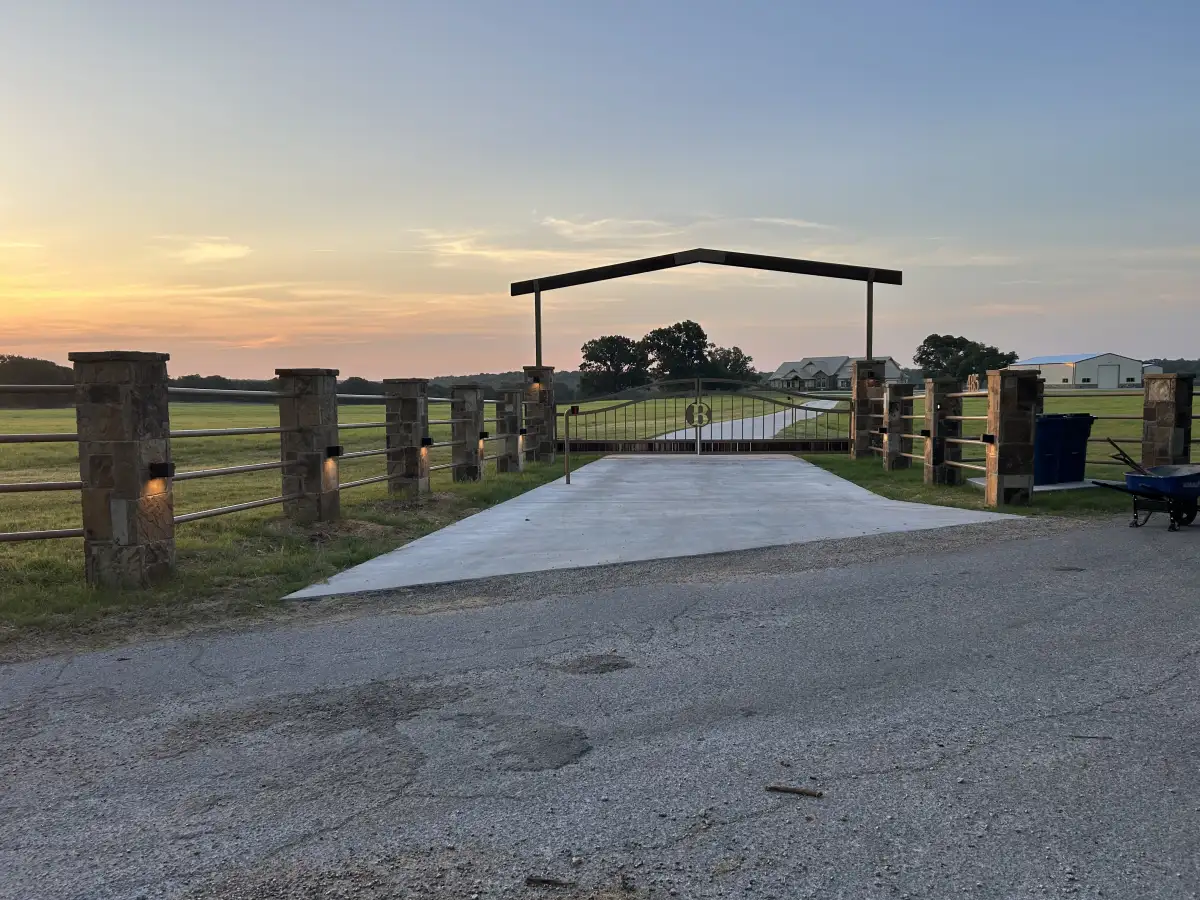 Rural landscape project with stone gate entry at sunset in Tin Top TX