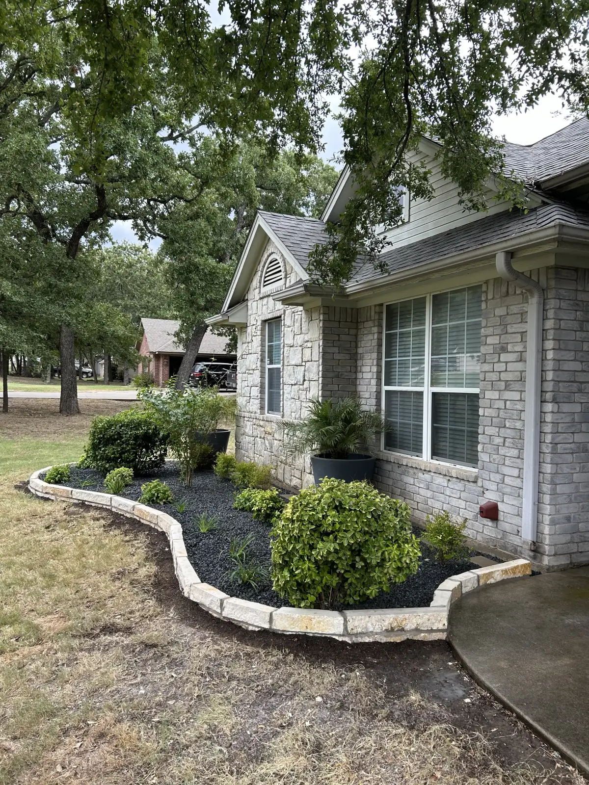 Custom landscape design with colorful flower beds at a Weatherford TX home