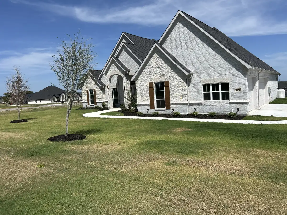 Custom landscape design for stone home in Weatherford TX